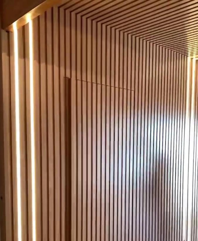 Closet planejado com ripado de madeira e iluminação embutida