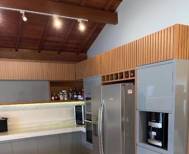 Detalhe de cozinha planejada com geladeira embutida e cafeteira integrada ao móvel